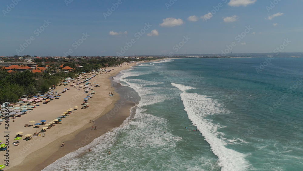 Aerial view sand beach with surfers and tourists, Kuta, Bali. surfers on water surface ocean catch wave. Seascape, beach, ocean, sky sea Travel concept