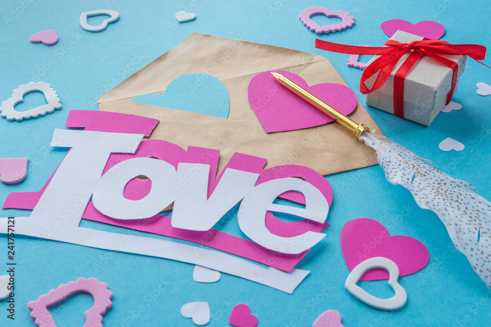Valentine's Day. Preparation for the holiday. Paper hearts, words of love cut  out of paper on a blue background. Handmade, creativity Stock Photo
