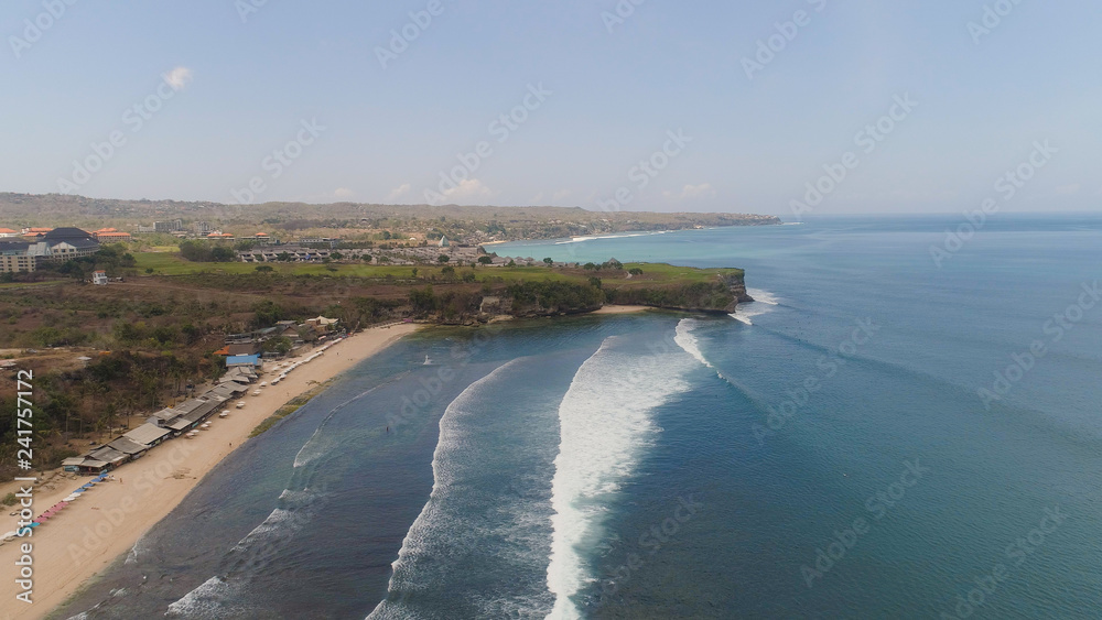Aerial view rocky seashore with sandy beach. seascape ocean surf and tropical beach large waves turquoise water crushing on beach Bali,Indonesia. Travel concept.