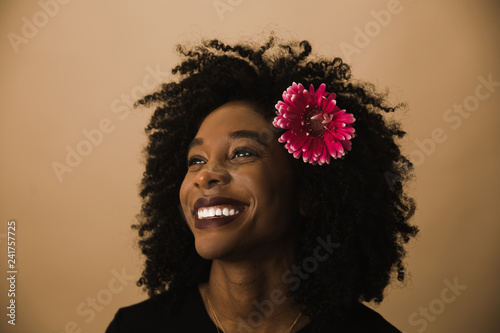 Smiling woman standing against beige background