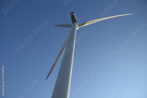Wind turbine on blue sky. Production of clean and renewable energy. Trentino, Italy