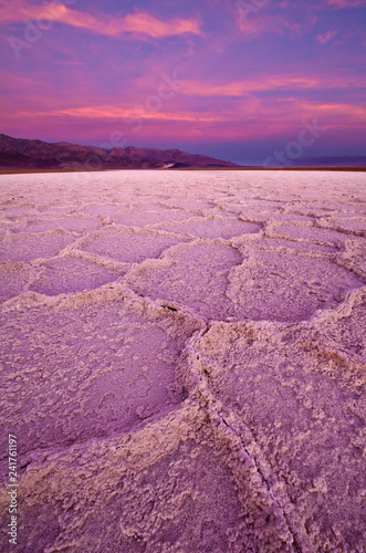 A vibrant pink sunrise turns the salt formations near Badwater in Death Valley pink.