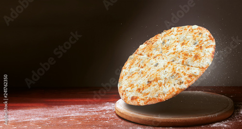 classic pizza on a dark wooden table background and a scattering of flour. pizza restaurant menu concept