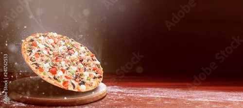 Obraz  z motywem classic pizza on a dark wooden table background and a scattering of flour. pizza restaurant menu concept
