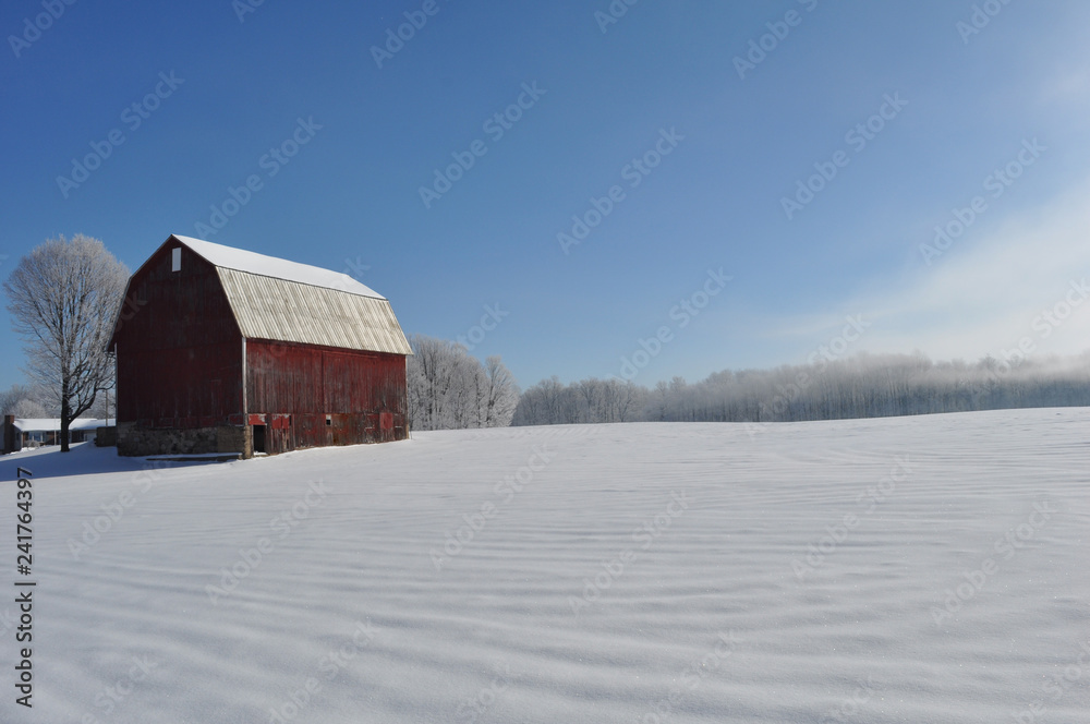 Snow covered field by the barn