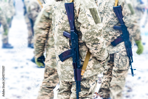 a detachment of soldiers with Kalashnikov assault rifles stand in formation to prepare for battle and offensive. photo