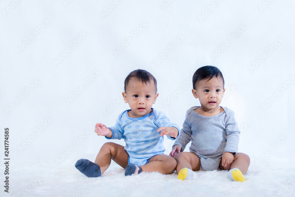 Newborn twins sit down.Newborn Babies Twins sit down in Bed.Lovely sit down of the newborns babies on the bed. Cute twins baby boy is shooting in the studio. fashion image of baby and family. Newborn twins sit down.Newborn Babies Twins sit down in Bed.Lovely sit down of the newborns babies on the bed. Cute twins baby boy is shooting in the studio. fashion image of baby and family.