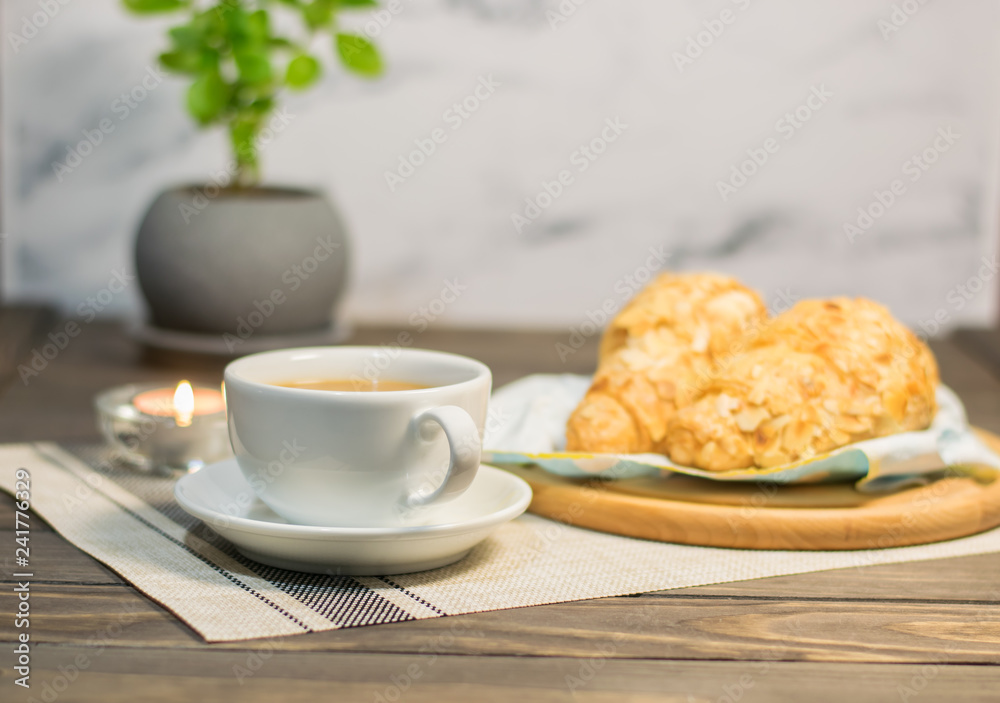 A cup of coffee with almond croissants, cozy evening