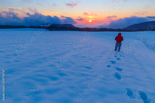 Young man watching the sunset in the mountains