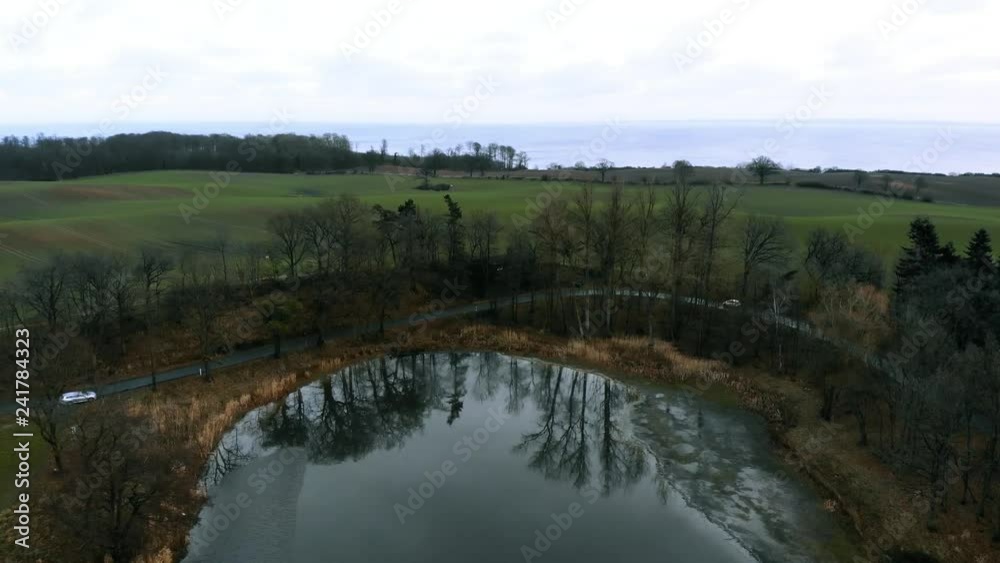 Holstein - Auto fährt an See vorbei Holstein - Auto fährt an See vorbei