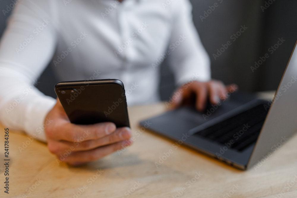 Portrait of Young man with a mobile phone sitting at cafe using laptop. Portrait of Young man with a mobile phone sitting at cafe using laptop.