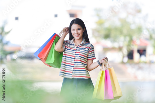 young woman shopping outside lady happy smiley holding shopping bag outdoors summer