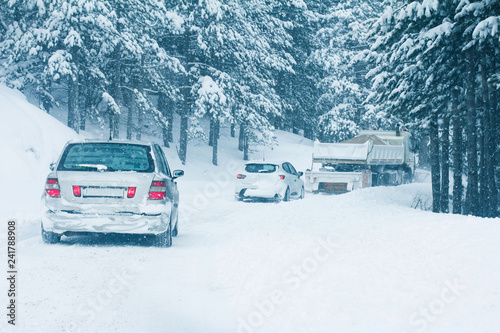 Traffic cars on winter road in snow blizzard