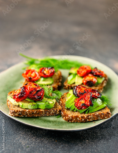 Avocado toasts with roasted tomatoes in a plate
