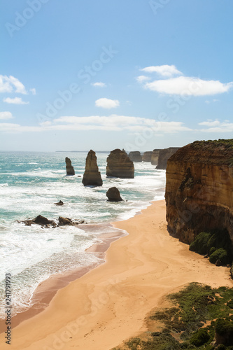 World famous Twelve Apostles rock formation on a hot summer day with white clouds and a light sea breeze (Great Ocean Road, Victoria, Australia)