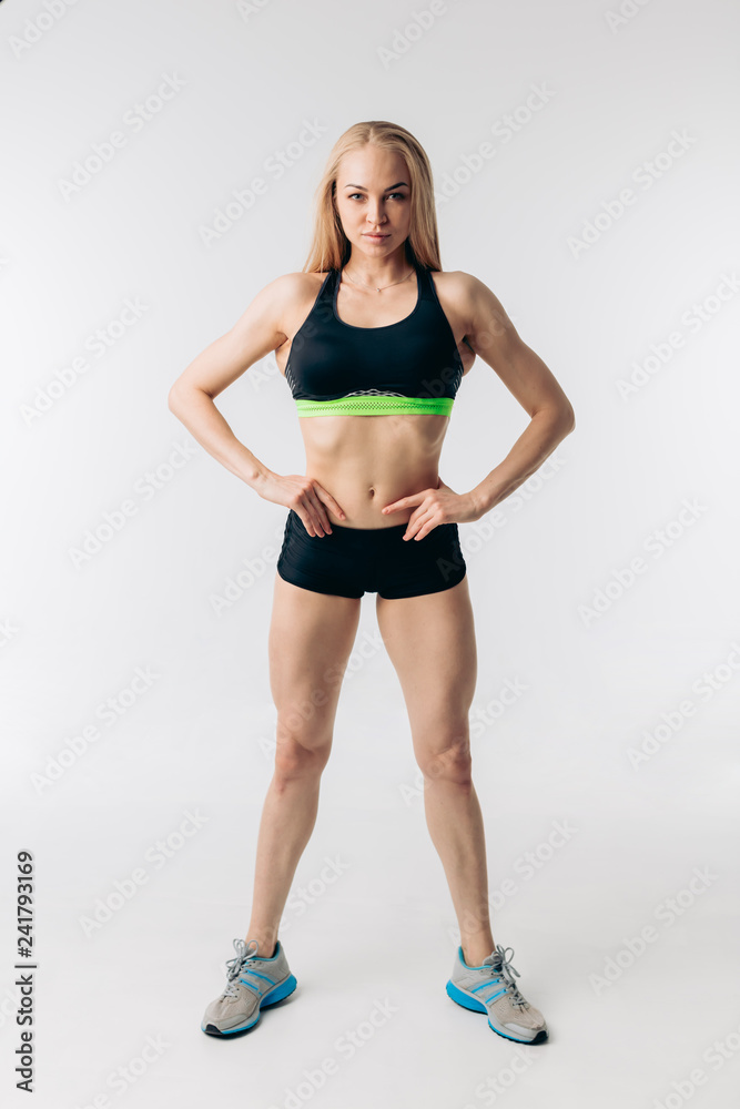awesome confident fit girl with hands on the hips looking at the camera. full length photo. sportswoman with a perfect abs. sport fan. diet. wellness awesome confident fit girl with hands on the hips looking at the camera. full length photo. sportswoman with a perfect abs. sport fan. diet. wellness