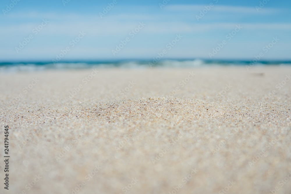 Close-up of sandy beach with blue sea Close-up of sandy beach with blue sea