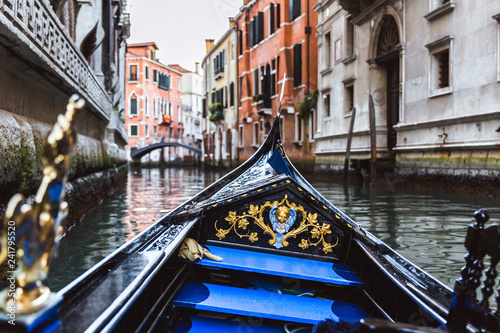 Traditional gondola on narrow canal in Venice, Italy