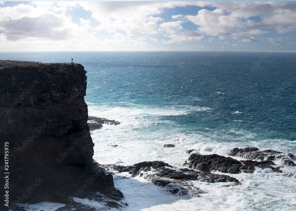 panorama of the cliff hit by the waves of the sea at sunset in Tenerife, Spain.