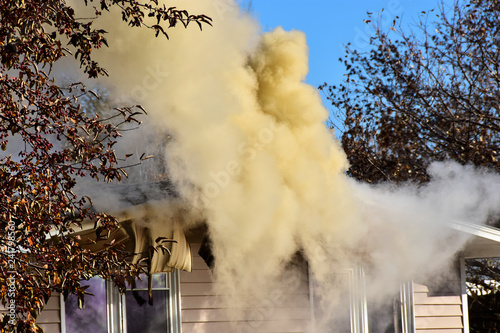 Smoke issueing from double wide mobile home on fire. photo