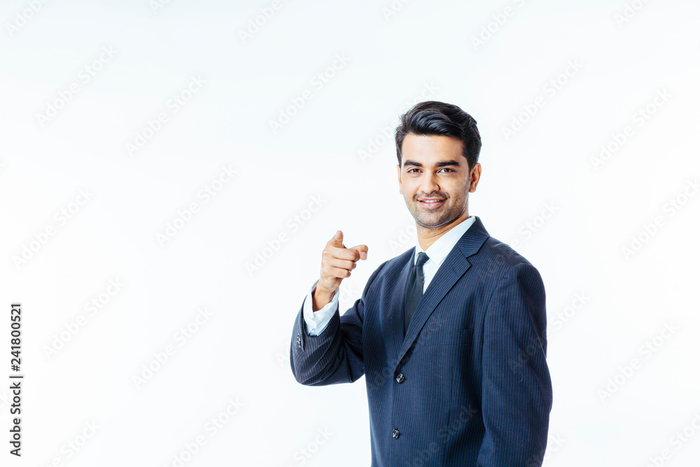 Title..Portrait of a smiling, successful businessman in black suit and tie pointing at camera isolated on white background Title..Portrait of a smiling, successful businessman in black suit and tie pointing at camera isolated on white background