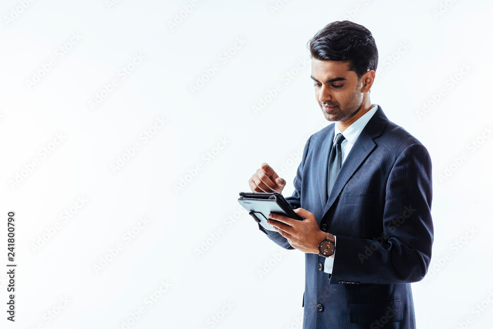 Portrait of a smiling man in business suit writing on electronic tablet pad and looking down, isolated on white background Portrait of a smiling man in business suit writing on electronic tablet pad and looking down, isolated on white background