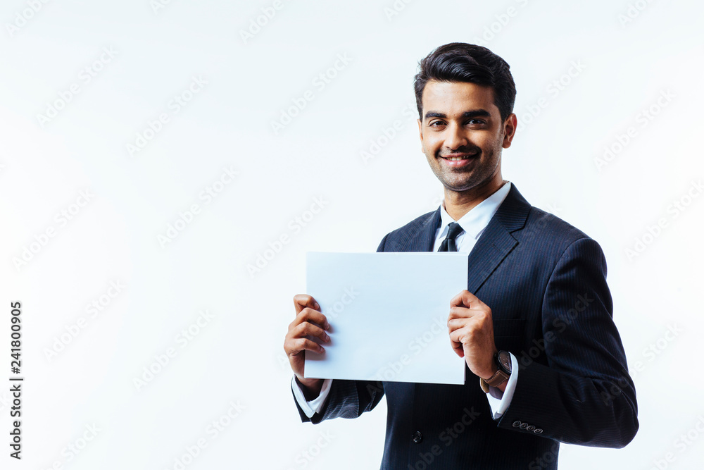 Portrait of a man in business suit, smiling, looking at camera, holding a white cardboard with both hands, isolated on white studio background Portrait of a man in business suit, smiling, looking at camera, holding a white cardboard with both hands, isolated on white studio background