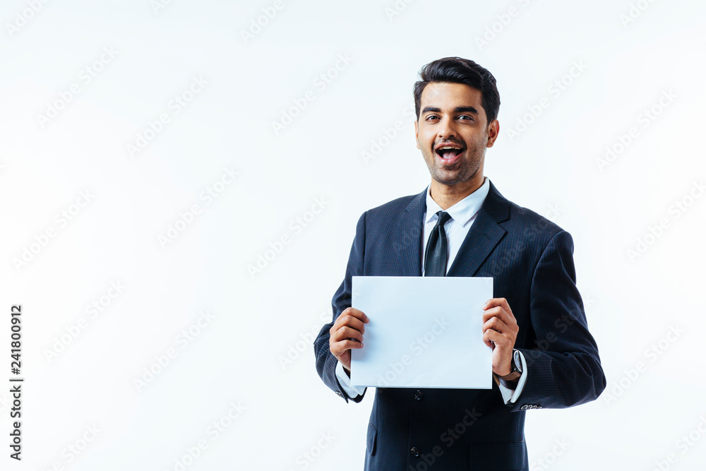 Portrait of a man in business suit, looking at camera, with open mouth, holding a white cardboard with both hands, isolated on white studio background Portrait of a man in business suit, looking at camera, with open mouth, holding a white cardboard with both hands, isolated on white studio background