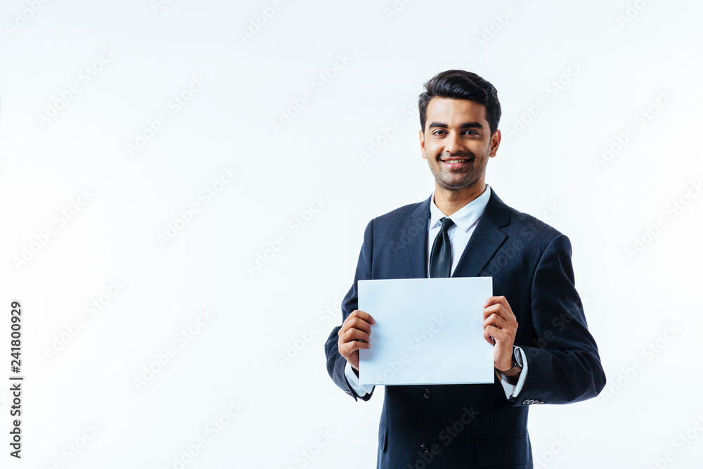 Portrait of a man in business suit, looking at camera, holding a white cardboard with both hands, isolated on white studio background Portrait of a man in business suit, looking at camera, holding a white cardboard with both hands, isolated on white studio background