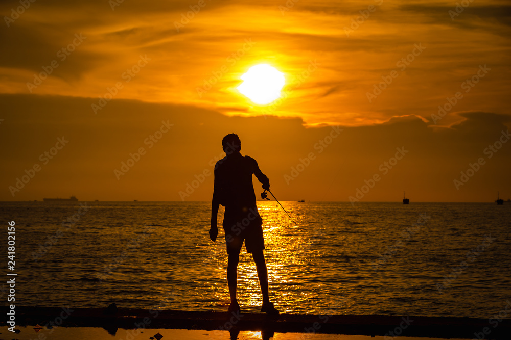 life portrait fishermen silhouette on the sea and the sunset over background evening time