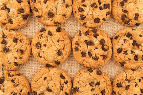 Flat lay of homemade chocolate chip cookies on burlap background. Close up.