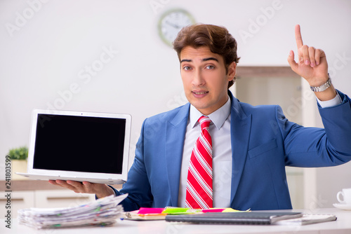 Young attractive businessman working in the office 