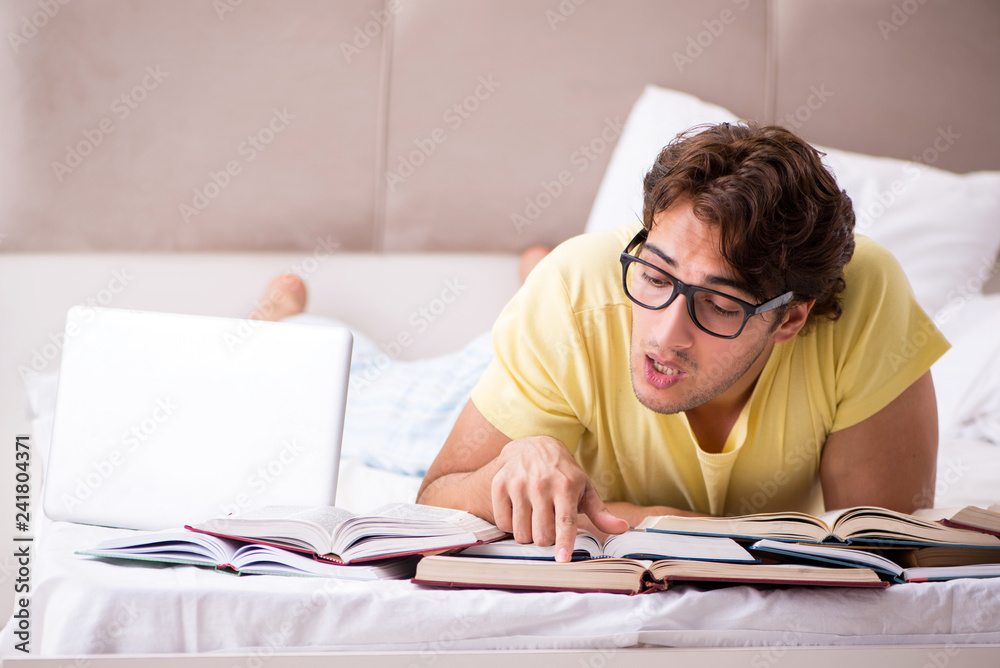 Young student studying in bed for exams Young student studying in bed for exams