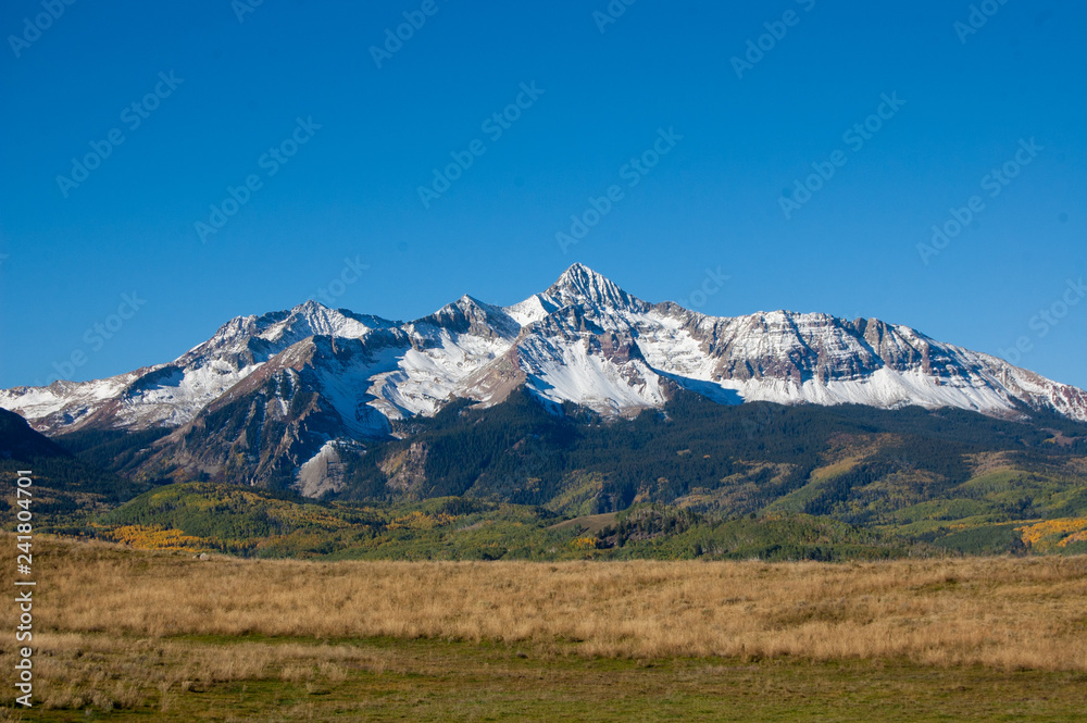 Rocky mountain with snow against blue sky