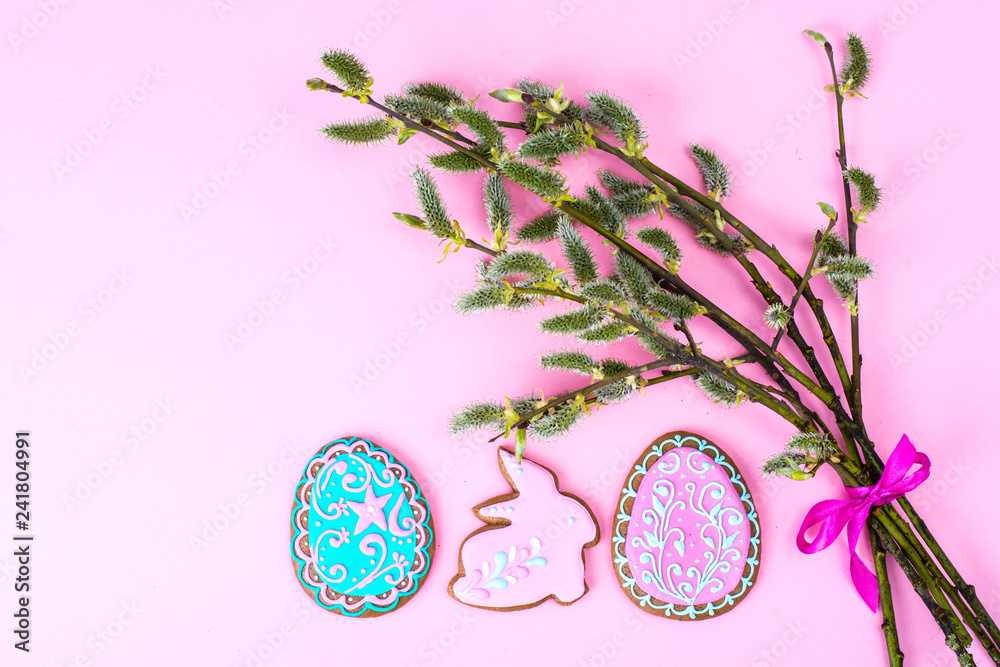 Willow branch and Easter cookie on bright background