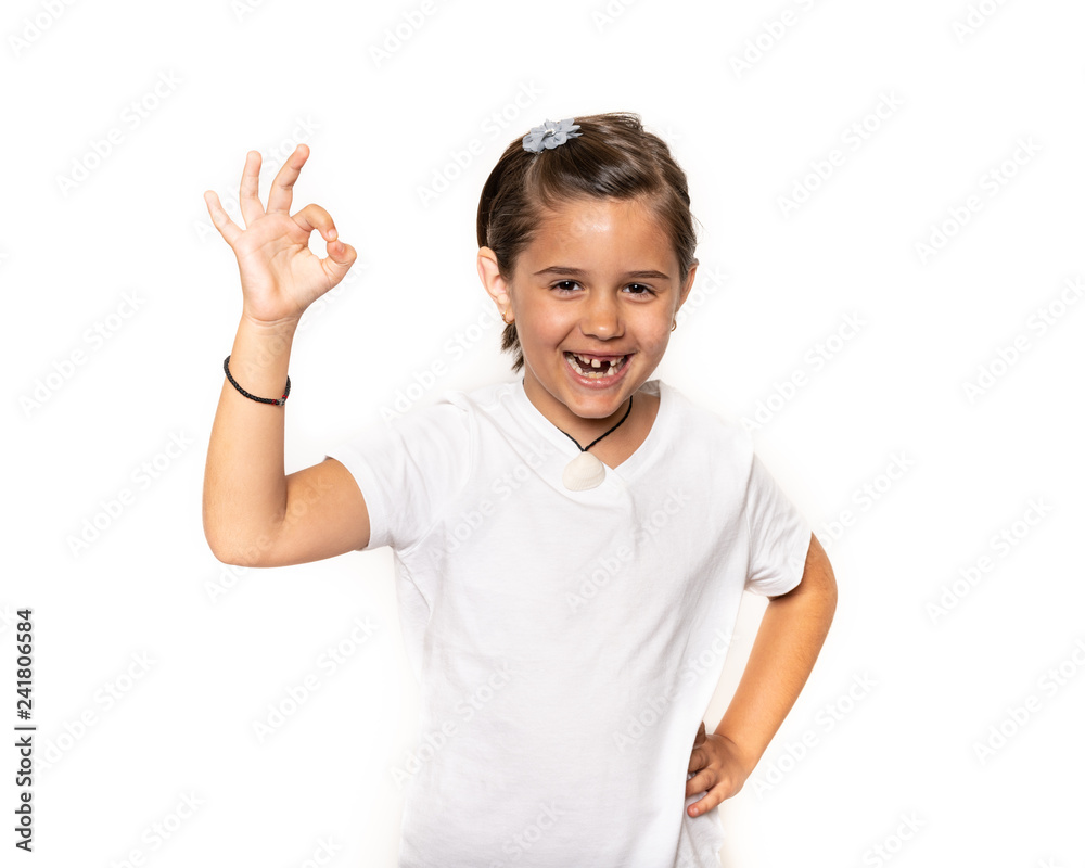 Young primary school aged school girl pointing ok or okay hand sign isolated on a white background. Young primary school aged school girl pointing ok or okay hand sign isolated on a white background.