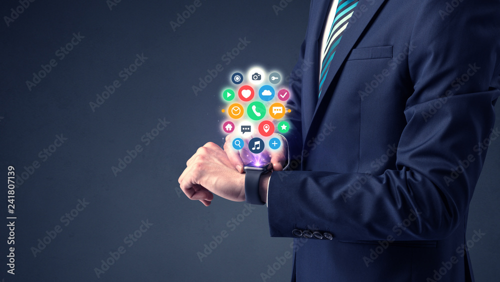 Businessman wearing smartwatch with colored application symbols on it. Businessman wearing smartwatch with colored application symbols on it.