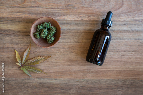 Marijuana buds and a glass bottle of cbd tincture