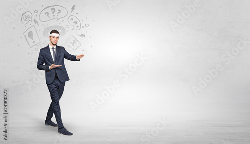 Young businessman in suit fighting with doodled symbols concept 