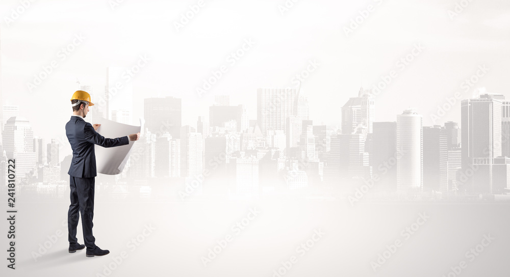 Young supervisor architect standing and looking at a big city panorama
Young supervisor architect standing and looking at a big city panorama
