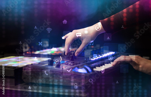 Hand mixing music on dj controller with social media concept icons 