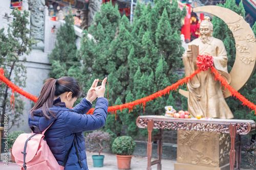 Young woman ties red rope and pray at Yue Lao (God of marriage) in Wong Tai Sin Temple, is well known for love and marriage prayers answered. landmark and popular for tourist attractions in Hong Kong photo