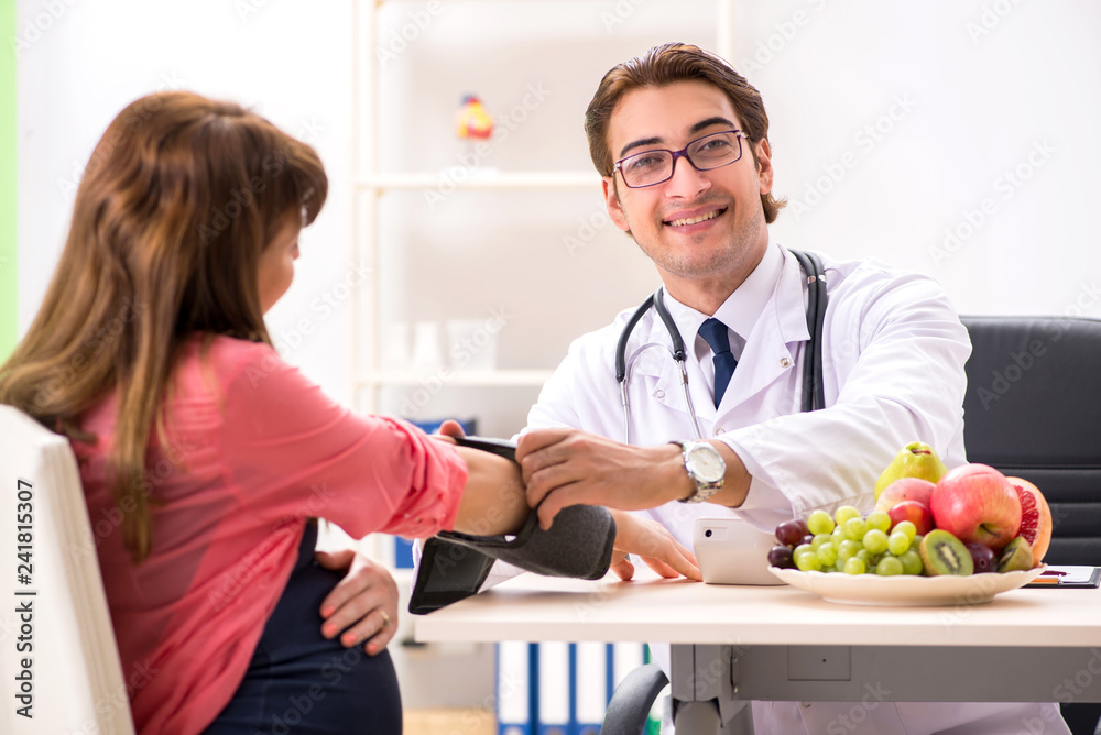 Pregnant woman visiting doctor discussing healthy diet