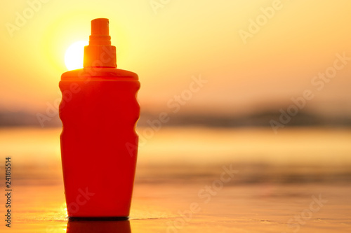 copyspace spf sunscreen sun block bottle on the sand by the sea shore. sunset viagra oil erotic massage romantic copy space photo