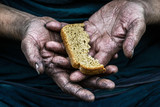 Dirty hands homeless poor man with piece of bread in modern capitalism society
