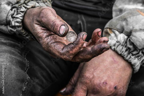 Homeless poor man with one cent coin in the street photo