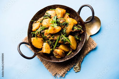 Aloo Palak sabzi - Potato cooked with spinach with added spices. a healthy Indian main course recipe. Served in a bowl, selective focus photo