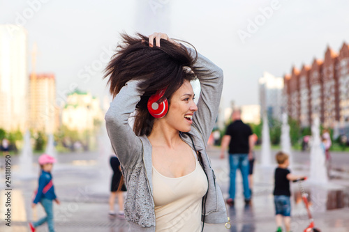 Girl listening to music streaming with headphones and making funny face.