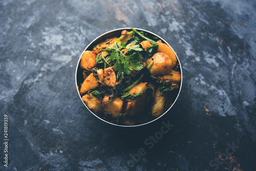 Aloo Palak sabzi - Potato cooked with spinach with added spices. a healthy Indian main course recipe. Served in a bowl, selective focus