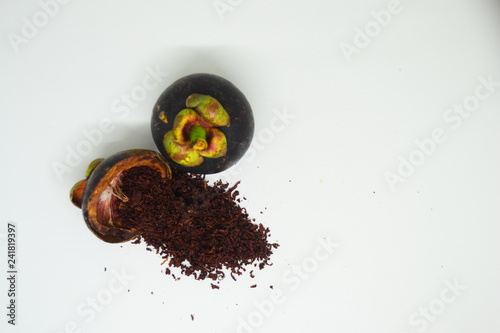 Tableau sur toile mangosteen peel and mangosteen peel powder on top of a wooden bowl